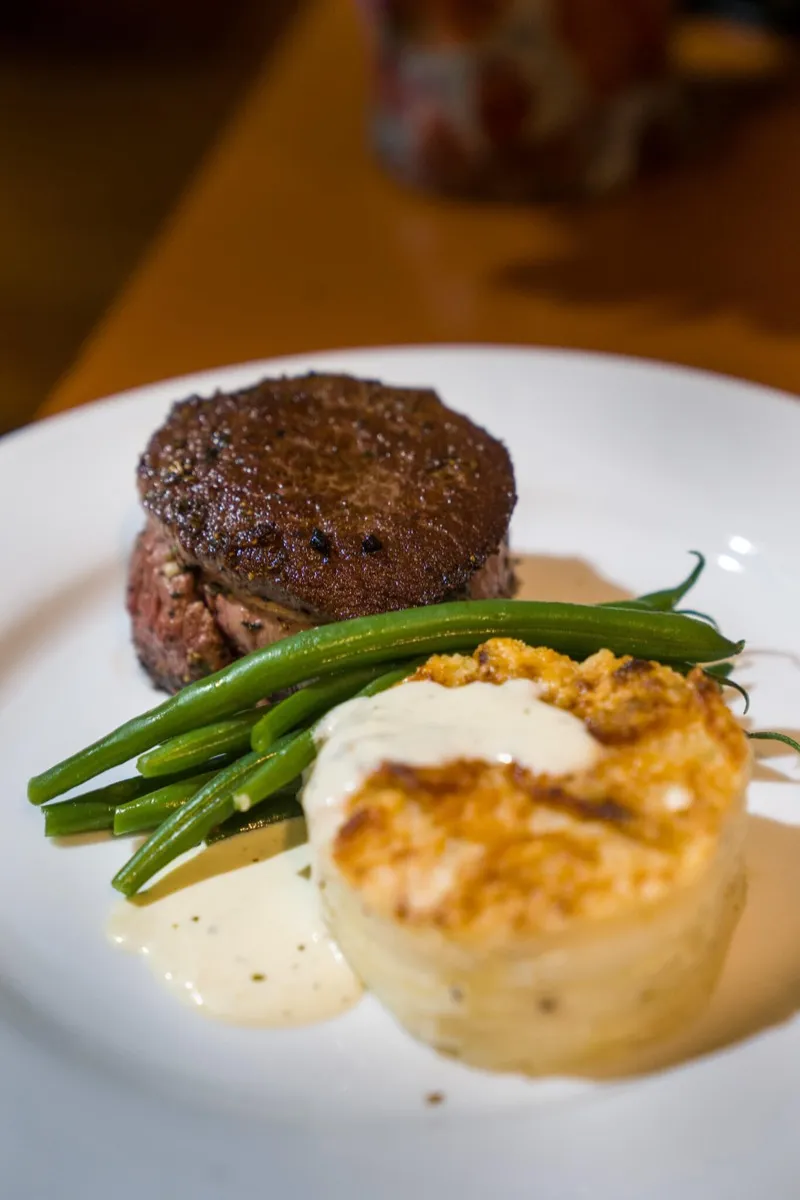Plated filet mignon with green beans and potato gratin